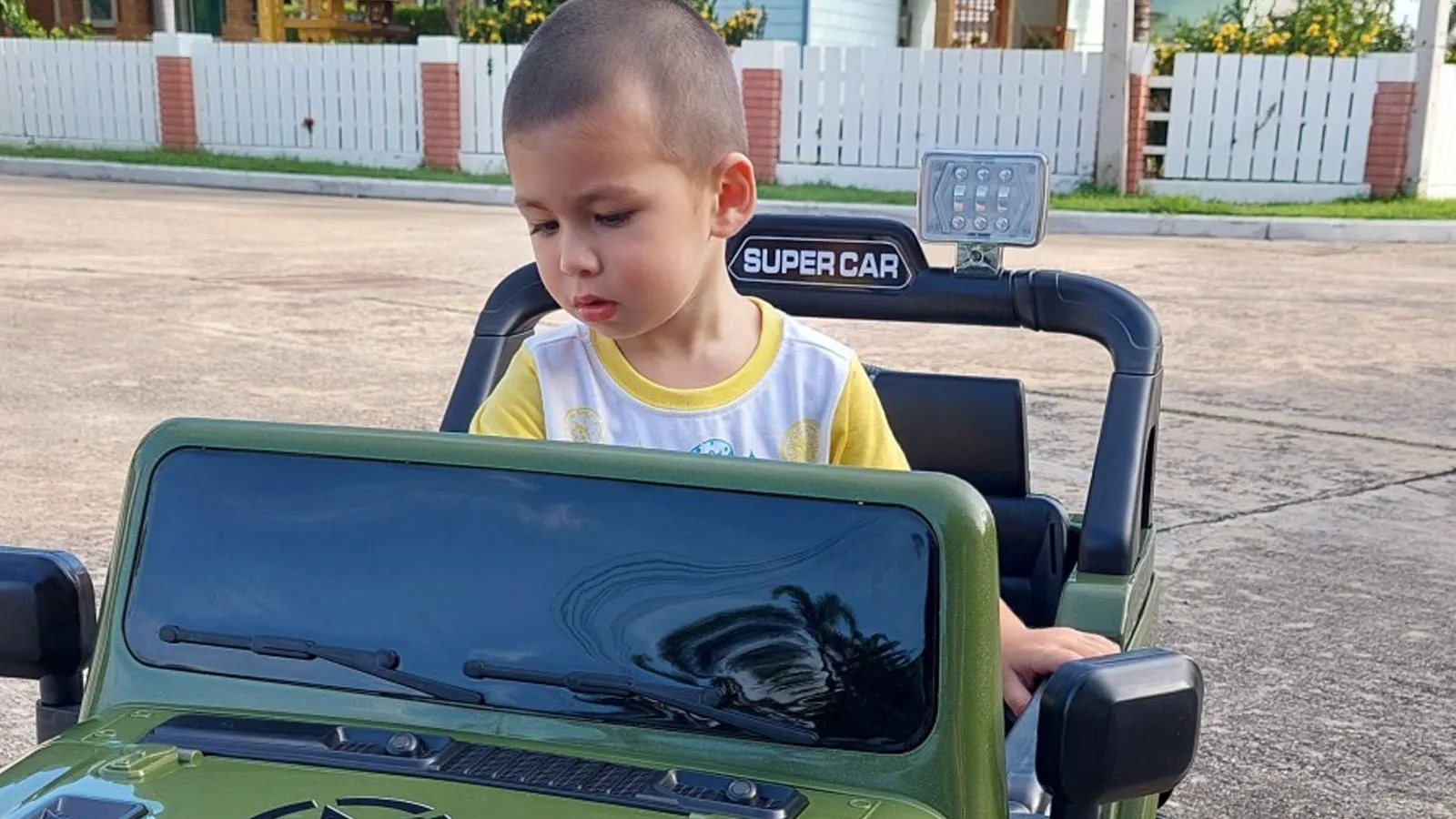 Enea sitting in his first little electric car.