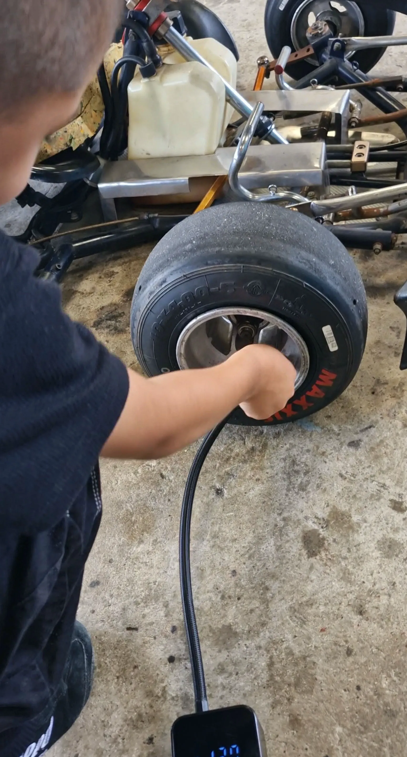 Enea checking the tire pressure on his kart before heading out on the track.